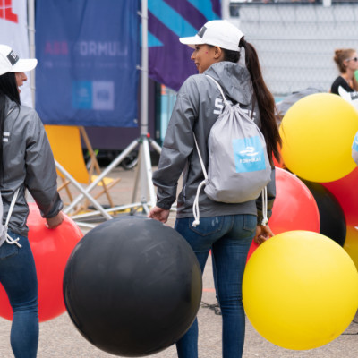 two women holding balloons and standing next to each other
