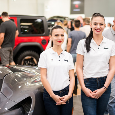 two women standing next to a car